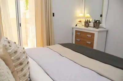 a bedroom with a bed with a dresser and a window at Apartamento Sofia in Pineda de Mar