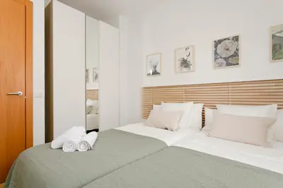 a bedroom with a large bed with two towels on it at AB North Barcelona Apartments in Santa Coloma