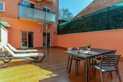 a patio with chairs and a table and a building at AB North Barcelona Apartments in Santa Coloma
