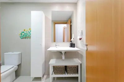 a bathroom with a sink and a toilet and a mirror at AB North Barcelona Apartments in Santa Coloma