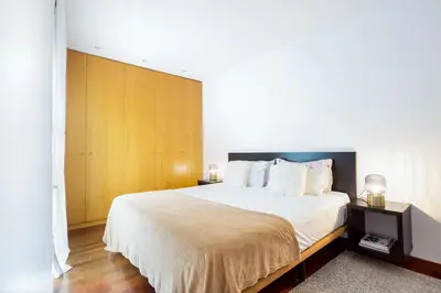 a bedroom with a large bed with white sheets at Enjoy Apartments Maria II in Barcelona