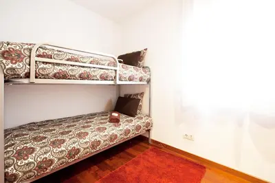 a bedroom with bunk beds and a red rug at Enjoy Apartments Maria II in Barcelona
