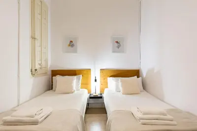 two beds in a room with white walls at Sagrada Familia II by Enjoy Apartments in Barcelona