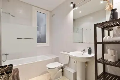 a white bathroom with a toilet and a sink at Sagrada Familia I by Enjoy Apartments in Barcelona