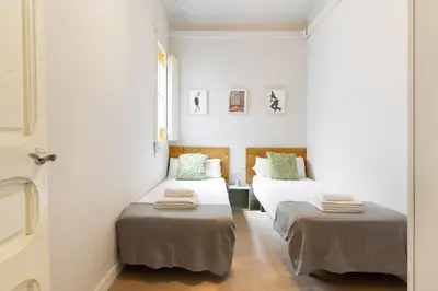 two beds in a room with white walls at Sagrada Familia IV by Enjoy Apartments in Barcelona