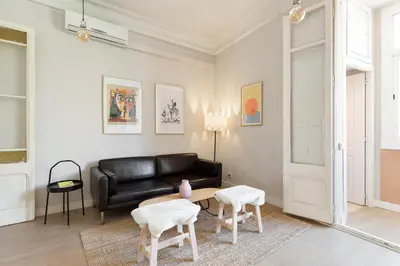 a living room with a black leather couch and chairs at Sagrada Familia IV by Enjoy Apartments in Barcelona