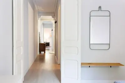 a hallway with white walls and a table and a mirror at Sagrada Familia IV by Enjoy Apartments in Barcelona