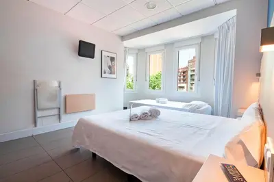 a white room with a bed and a window at Putxet by gaiarooms in Barcelona