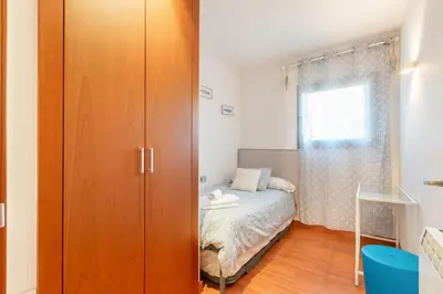 a bedroom with a bed and a large wooden closet at Sant Sebastià Moderno apartamento a 100 metros de la playa in Sitges