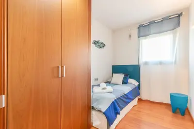 a bedroom with a bed and a wooden closet at Sant Sebastià Moderno apartamento a 100 metros de la playa in Sitges