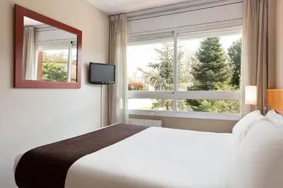 a bedroom with a white bed and a window at PARK SEDO Aparthotel in Rubí