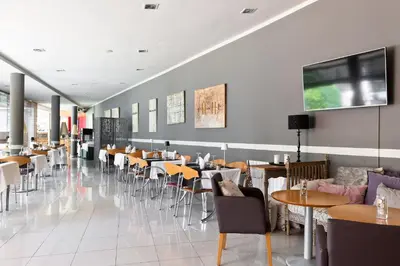 a restaurant with tables and chairs in a room at PARK SEDO Aparthotel in Rubí