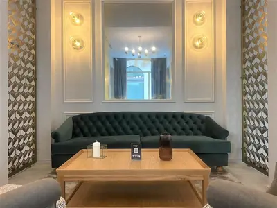 a living room with a green couch and a table at Lamaro Hotel Barcelona - Preferred Hotels & Resorts - Lifestyle Collection in Barcelona