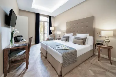 a bedroom with a bed and a desk and a television at Lamaro Hotel Barcelona - Preferred Hotels & Resorts - Lifestyle Collection in Barcelona