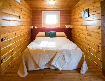 a bedroom with a bed in a wooden room at Hotel Somlom - ECO Friendly Montseny in Sant Esteve de Palautordera