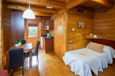 a room with a bed and a table in a cabin at Hotel Somlom - ECO Friendly Montseny in Sant Esteve de Palautordera