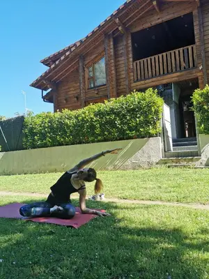 a woman doing a yoga pose with a dog at Hotel Somlom - ECO Friendly Montseny in Sant Esteve de Palautordera