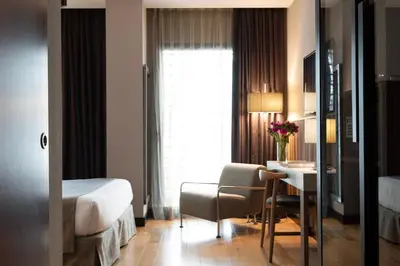 a hotel room with a bedroom with a desk and a bed at Hotel Villa Emilia in Barcelona