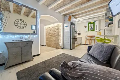 a living room with a couch and a kitchen at Hauzify I Novavila Centre Rooms in Vilanova i la Geltrú