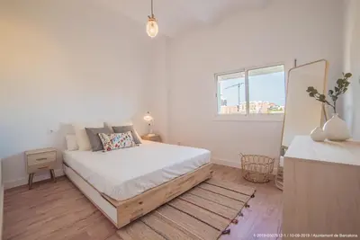 a white bedroom with a bed and a window at Welcomy Poblenou in Barcelona