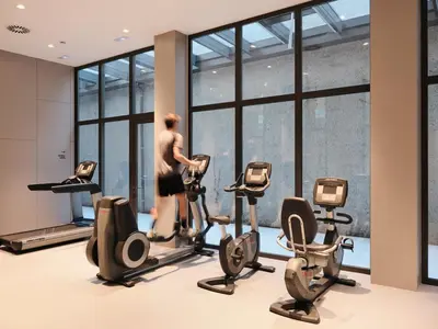 a man walking on a treadmill in a gym at Qgat Restaurant Events & Hotel in Sant Cugat del Vallès