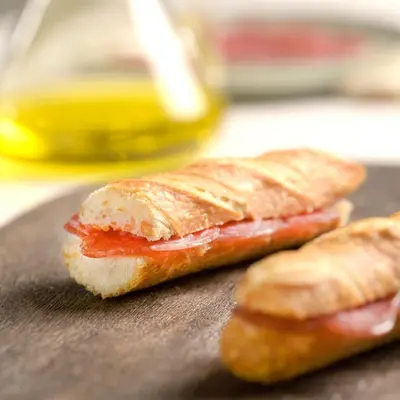 two halves of a sandwich on a cutting board at Eco Boutique Hostal Grau in Barcelona
