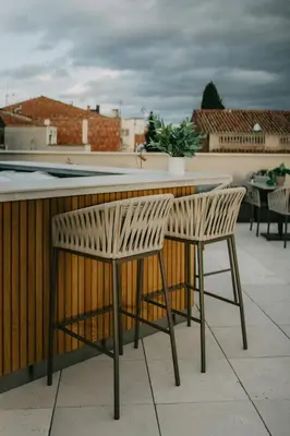 a bar with two chairs and a table on a patio at Hotel Petit Luxe in Terrassa