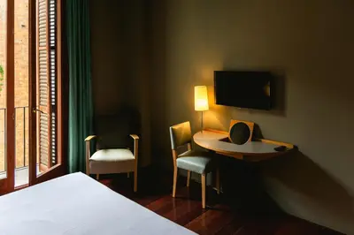 a hotel room with a bed and a table and chairs at Fonda Hotel 1771 in Granollers