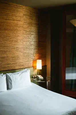 a bedroom with a bed and a table with a lamp at Fonda Hotel 1771 in Granollers
