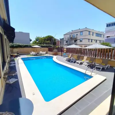 a swimming pool on the roof of a building at Hotel 153 in Castelldefels