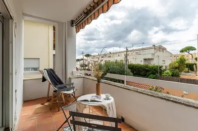 a balcony with two chairs and a table and a window at Canela Homes COSTA CASA AILA in Castelldefels