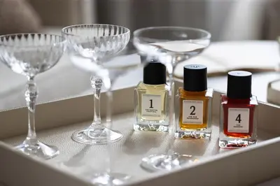 a table with four bottles of perfume and wine glasses at METT Barcelona GL - A Leading Hotel of the World in Barcelona