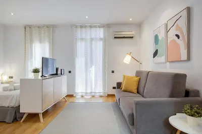 a living room with a couch and a bed at Feelathome Center Apartments in Barcelona