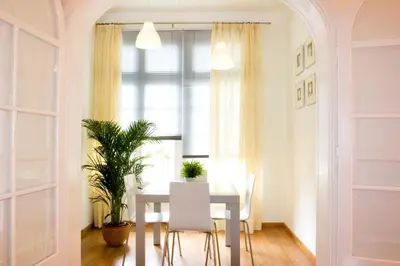 a dining room with a table and chairs and a window at Feelathome Center Apartments in Barcelona