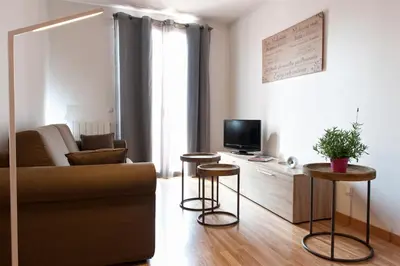 a living room with a couch and two stools at MH Apartments Liceo in Barcelona