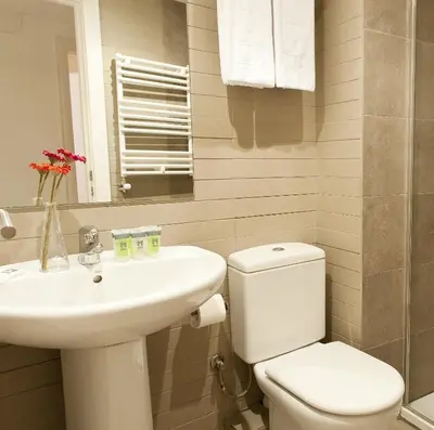 a white bathroom with a sink and a toilet at MH Apartments Liceo in Barcelona