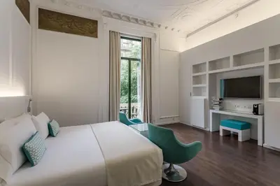 a hotel room with a bed and a tv at Room Mate Carla, Barcelona in Barcelona