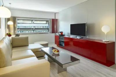 a living room with a couch and a flat screen tv at NH Collection Barcelona Constanza in Barcelona