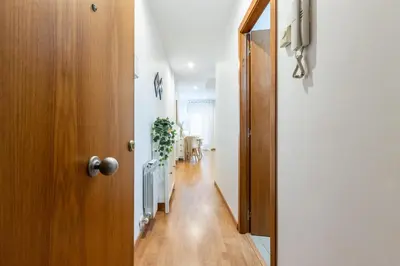 a hallway with a wooden door and a dining room at Fantástico loft cerca centro by Lofties in Terrassa