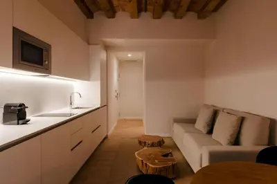 a kitchen and a living room with a couch and a table at Hotel Hamsa House in Barcelona