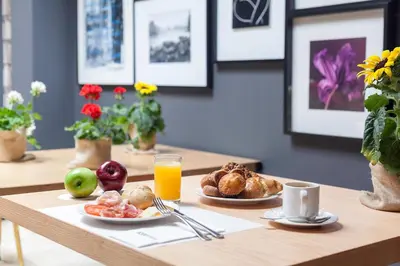 a wooden table with breakfast foods and orange juice at Acta BCN 40 in Barcelona