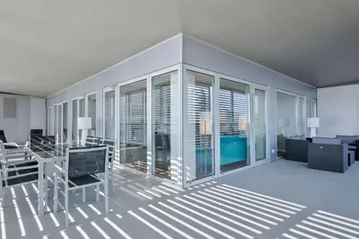 a living room with a table and chairs and windows at Alcam Llum Deluxe in Barcelona