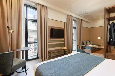 a hotel room with a bed and a tv at Hotel Medinaceli 4 Estrellas SUPERIOR in Barcelona