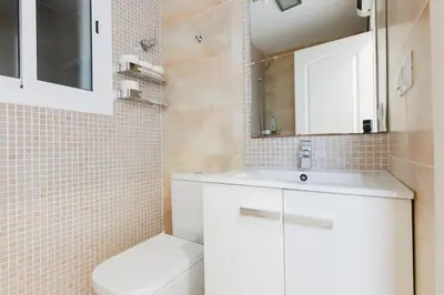 a bathroom with a white sink and a toilet at ApartEasy - Private Terrace, 3-Bedroom Apartment in Barcelona