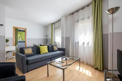 a living room with a blue couch and a glass table at Apartments Sata Park Guell Area in Barcelona
