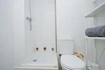 a white bathroom with a toilet and a shower at Barcelona City North Hostal in Barcelona