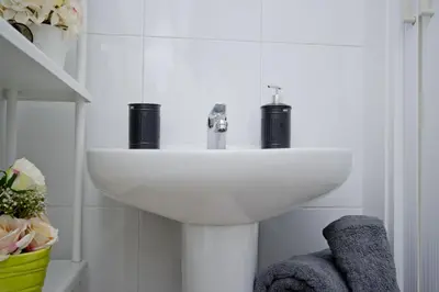 a white sink in a white bathroom with towels at Barcelona City North Hostal in Barcelona