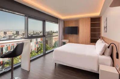 a bedroom with a white bed and large windows at Four Points by Sheraton Barcelona Diagonal in Barcelona