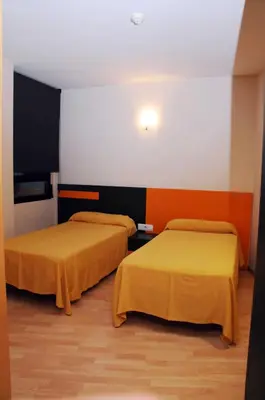 two beds in a room with orange and black at Llagotel in La Llagosta