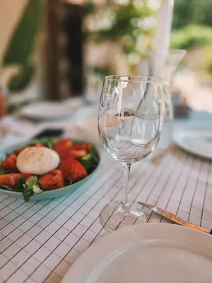 a glass of wine sitting next to a plate of food at Casa Om in Dosríus